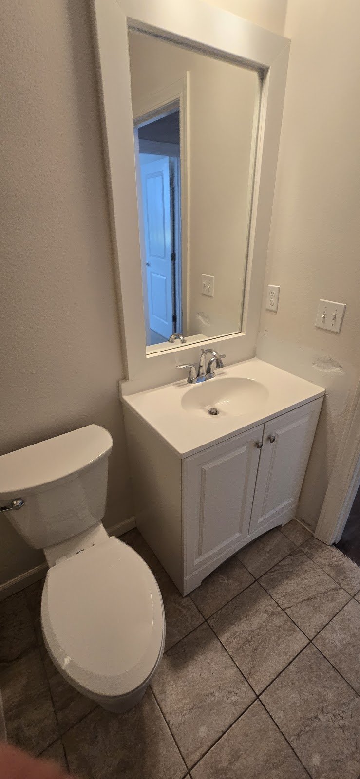 Toilet and vanity fixtures in a bathroom.