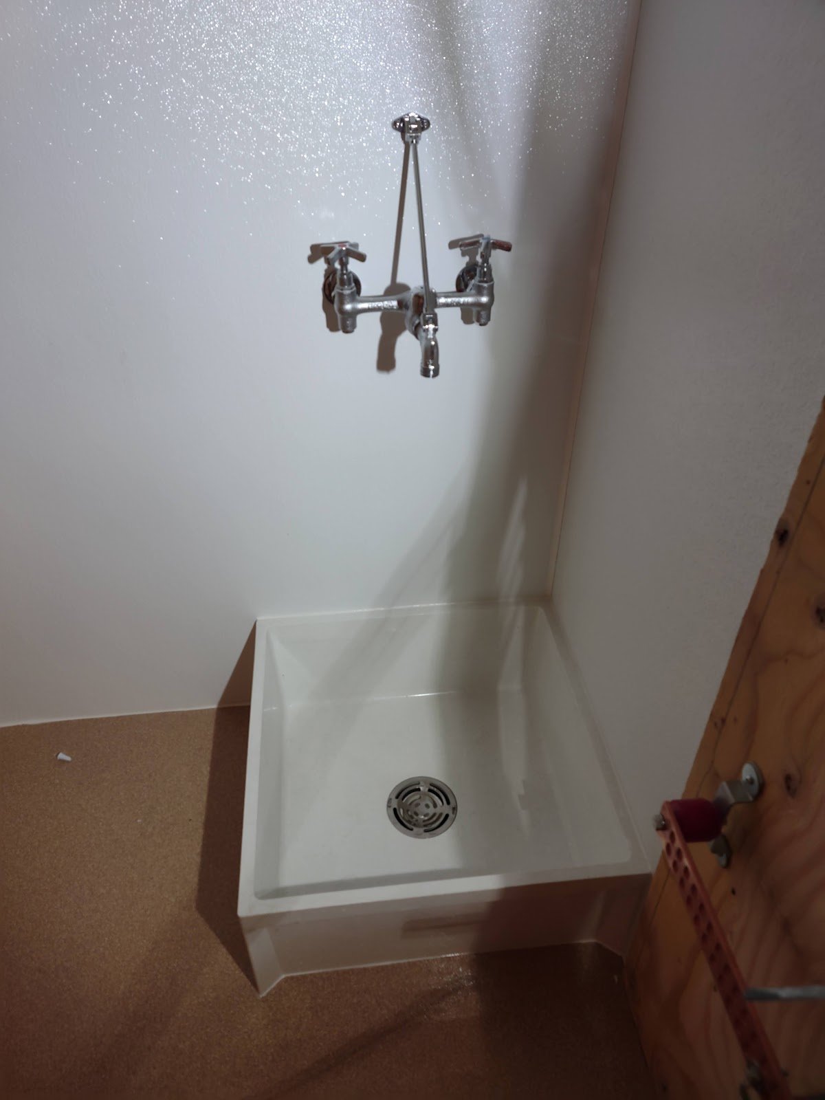 Shower fixture and exposed piping detail.