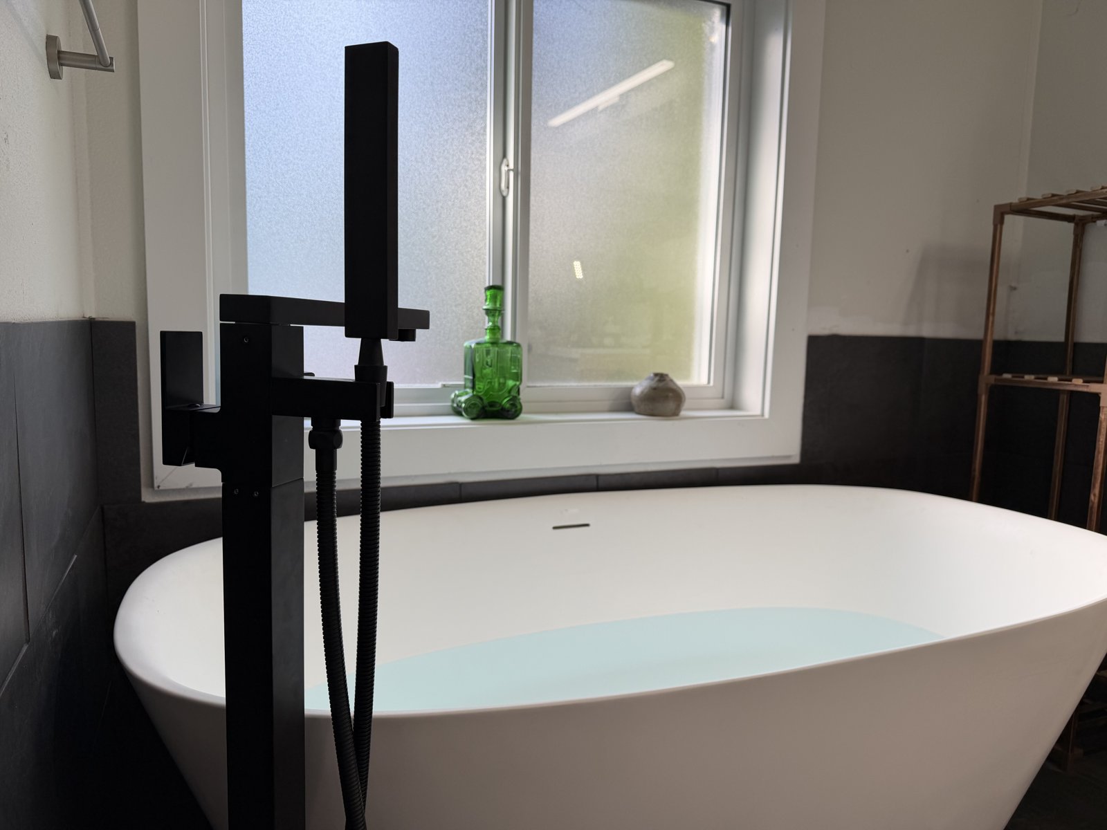 Trailblazer bathroom project with a freestanding tub and matte-black floor filler